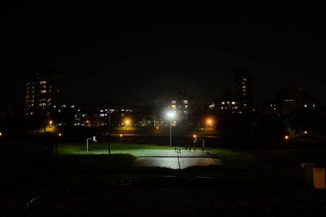 Baseball pitcher on the mound at night under stadium lights with empty bases